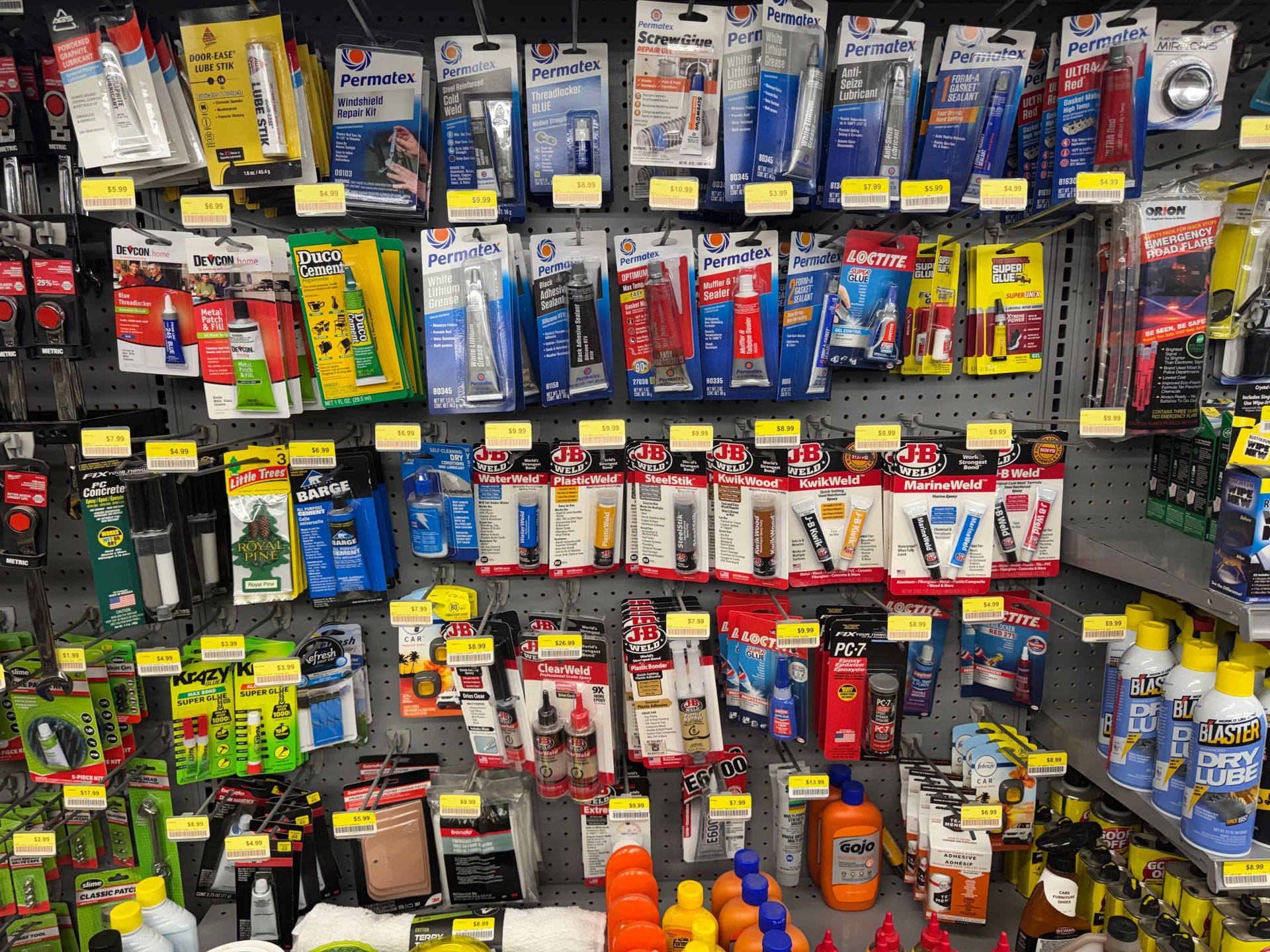 Person using caulk gun to seal a gap between wooden trim and floor.