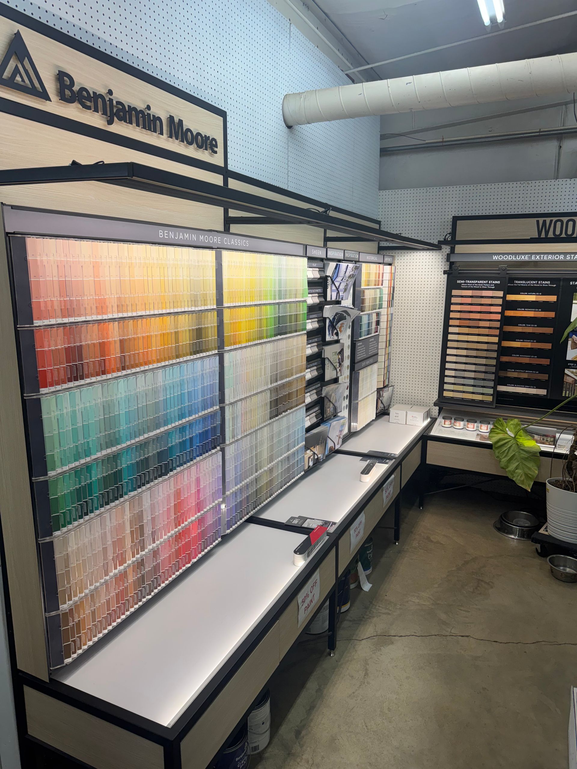 Lawnmower on green grass, being pushed by a person in a backyard.