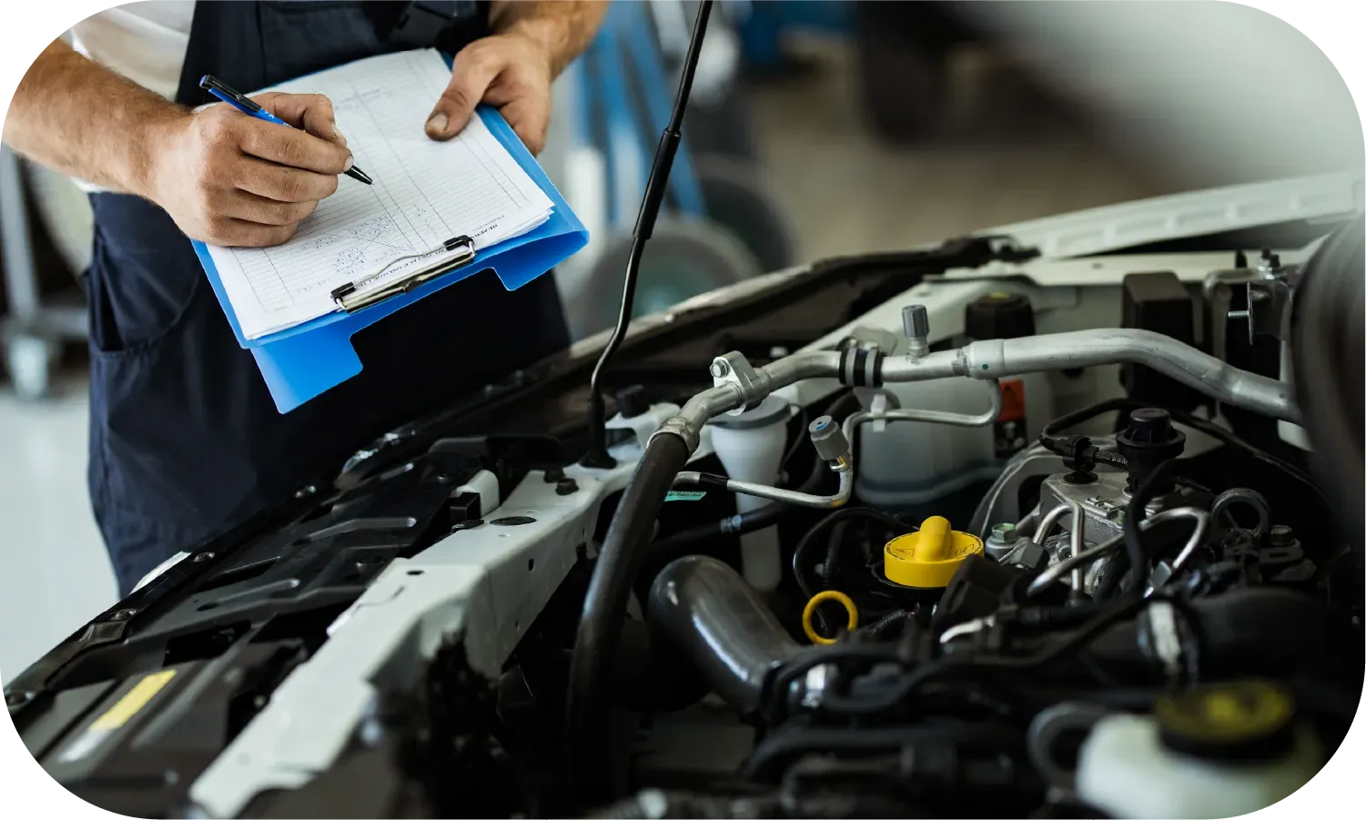 A mechanic is writing on a clipboard while looking at the engine of a car.