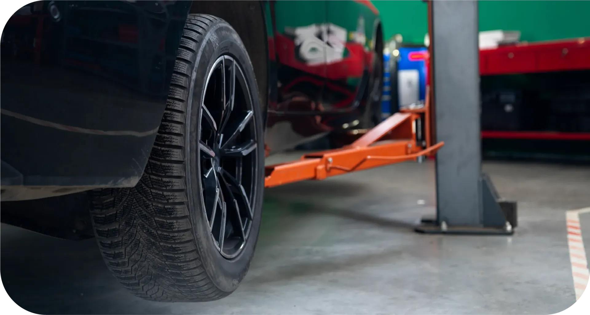 A car is sitting on a lift in a garage.