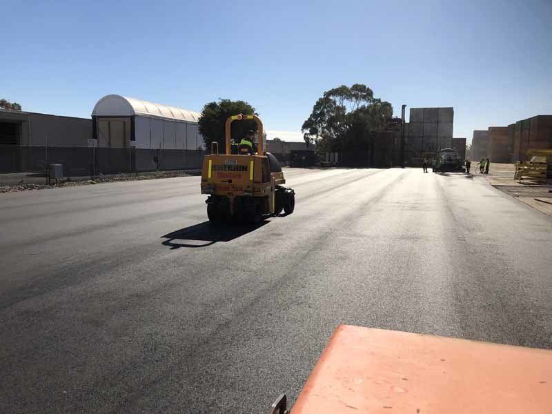 newly paved parking lot with steam roller