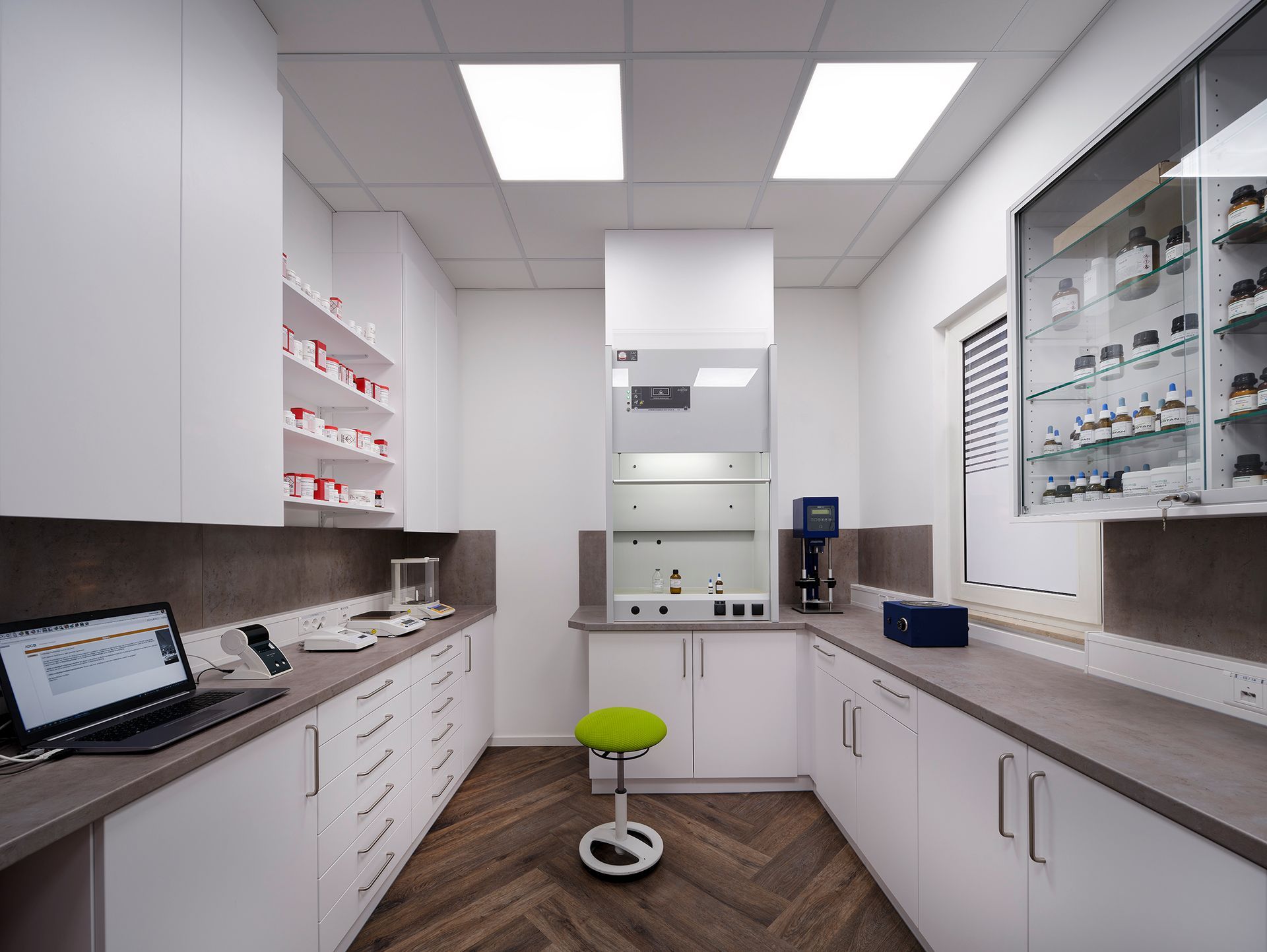 Ein Labor mit einem grünen Hocker und einem Laptop auf der Theke