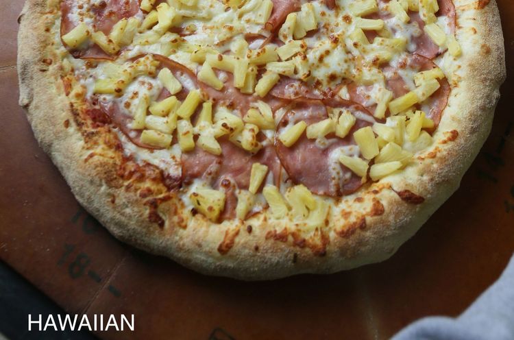 A pizza with four different toppings is sitting on a table.