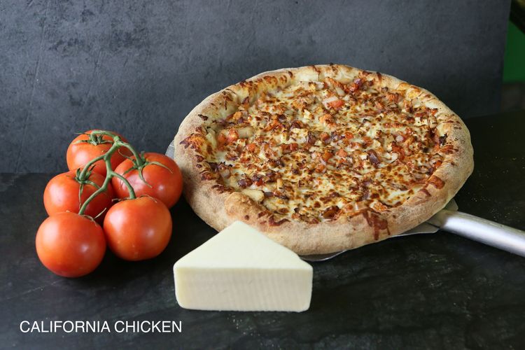 A pizza with four different toppings is sitting on a table.