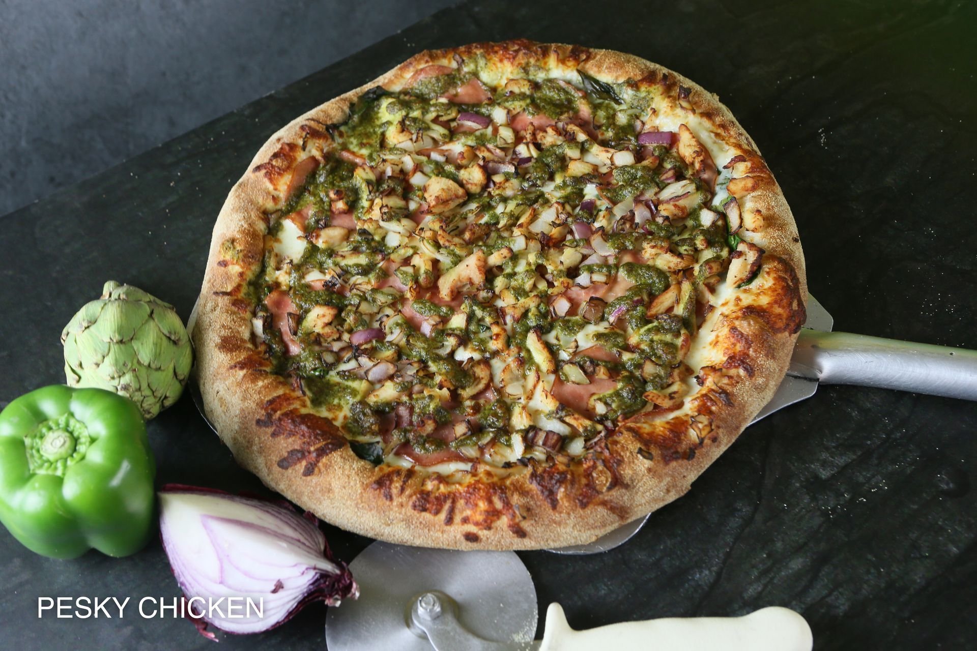 A pizza with four different toppings is sitting on a table.
