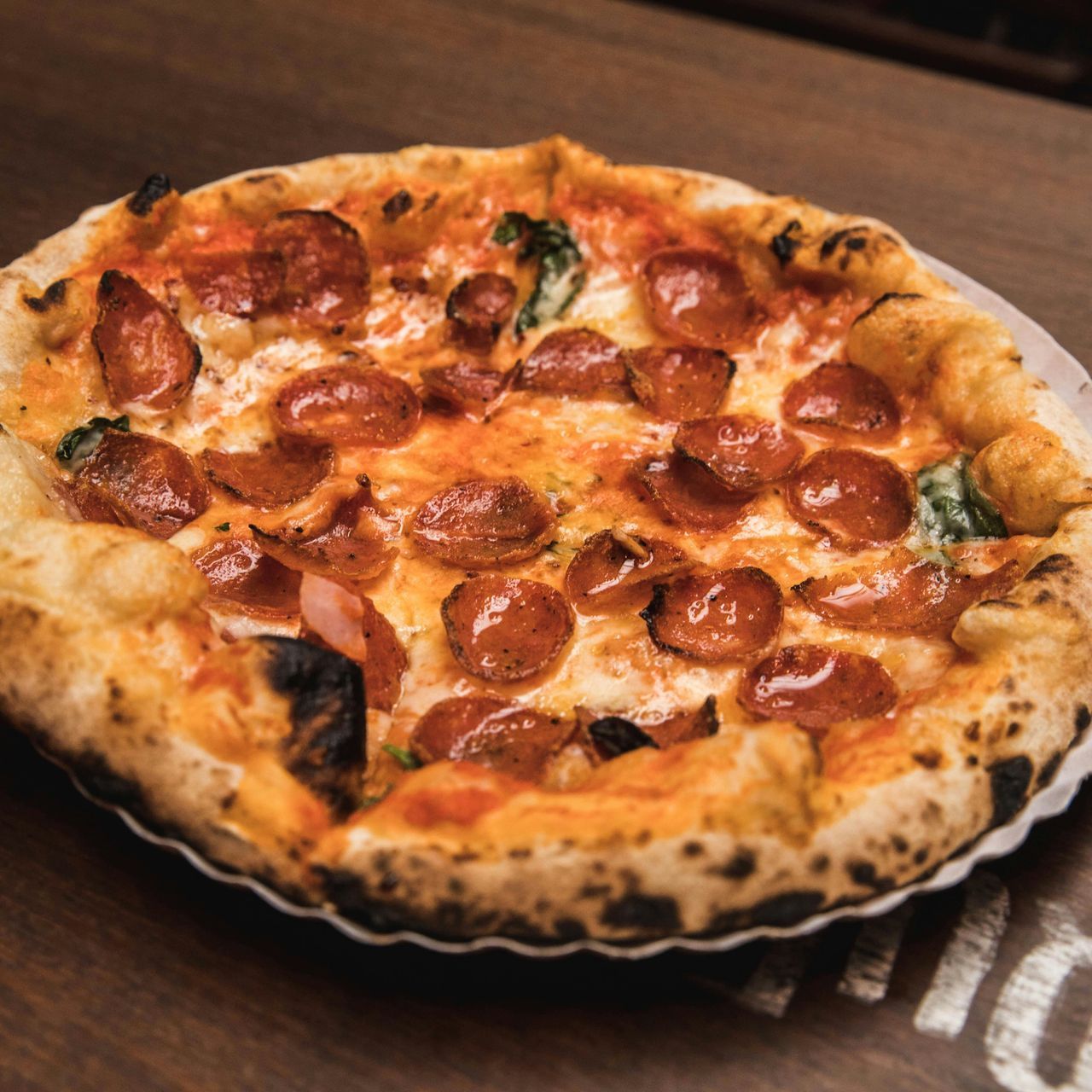 A pizza with four different toppings is sitting on a table.