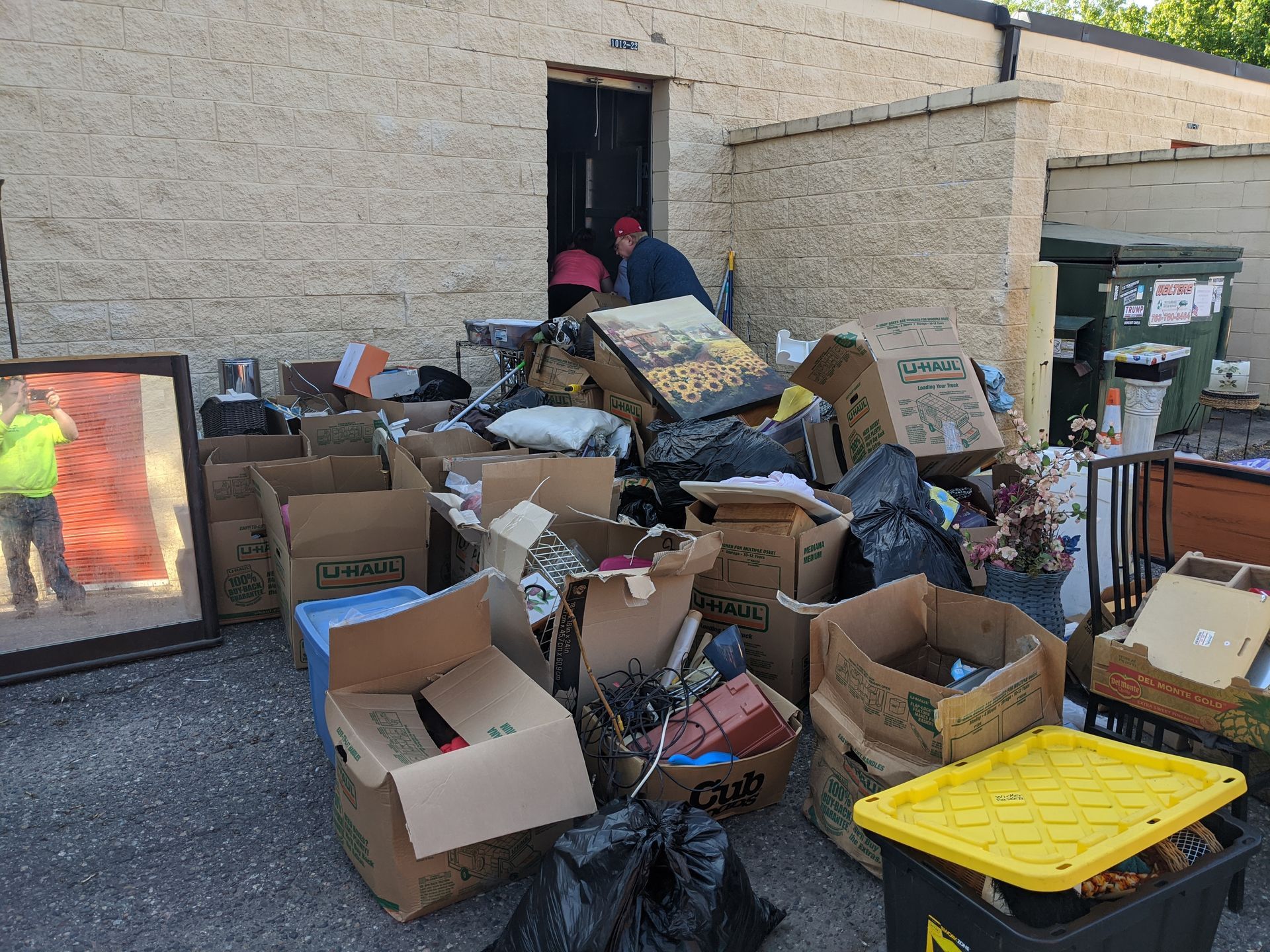 A pile of cardboard boxes and trash in front of a building.