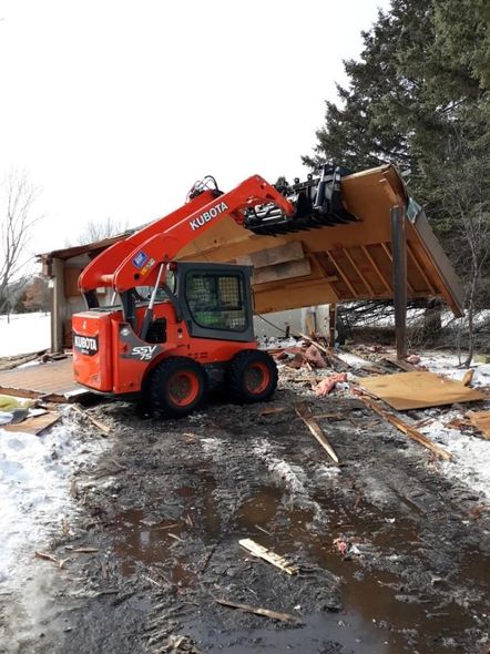 a kubota skid steer is being used to demolish a building