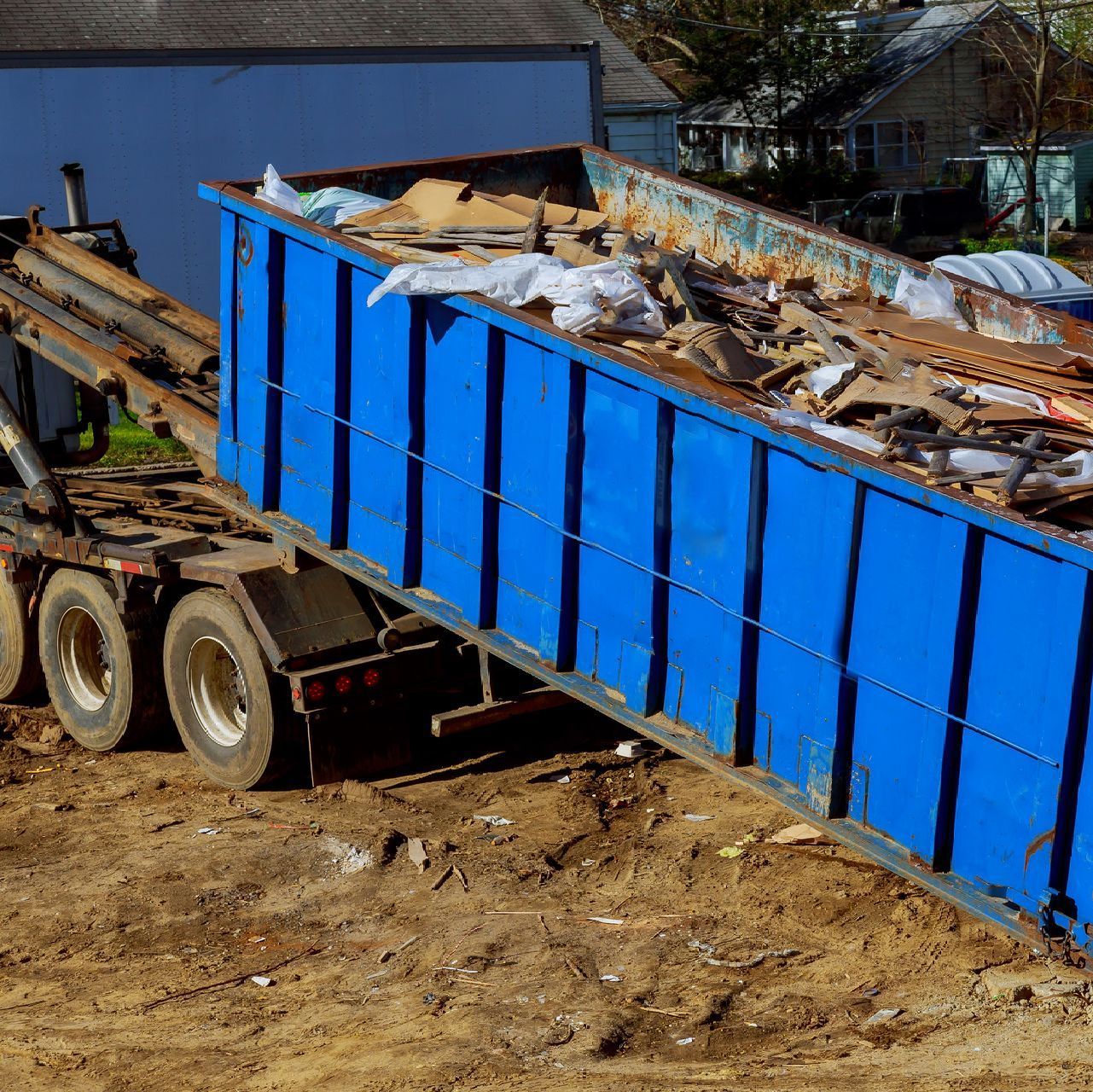a blue dumpster is filled with a lot of trash