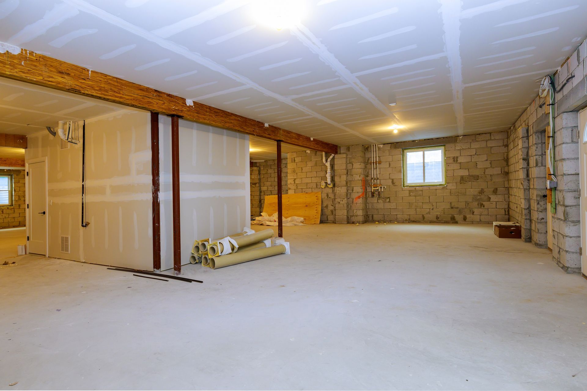 An empty basement with a brick wall and a white ceiling.