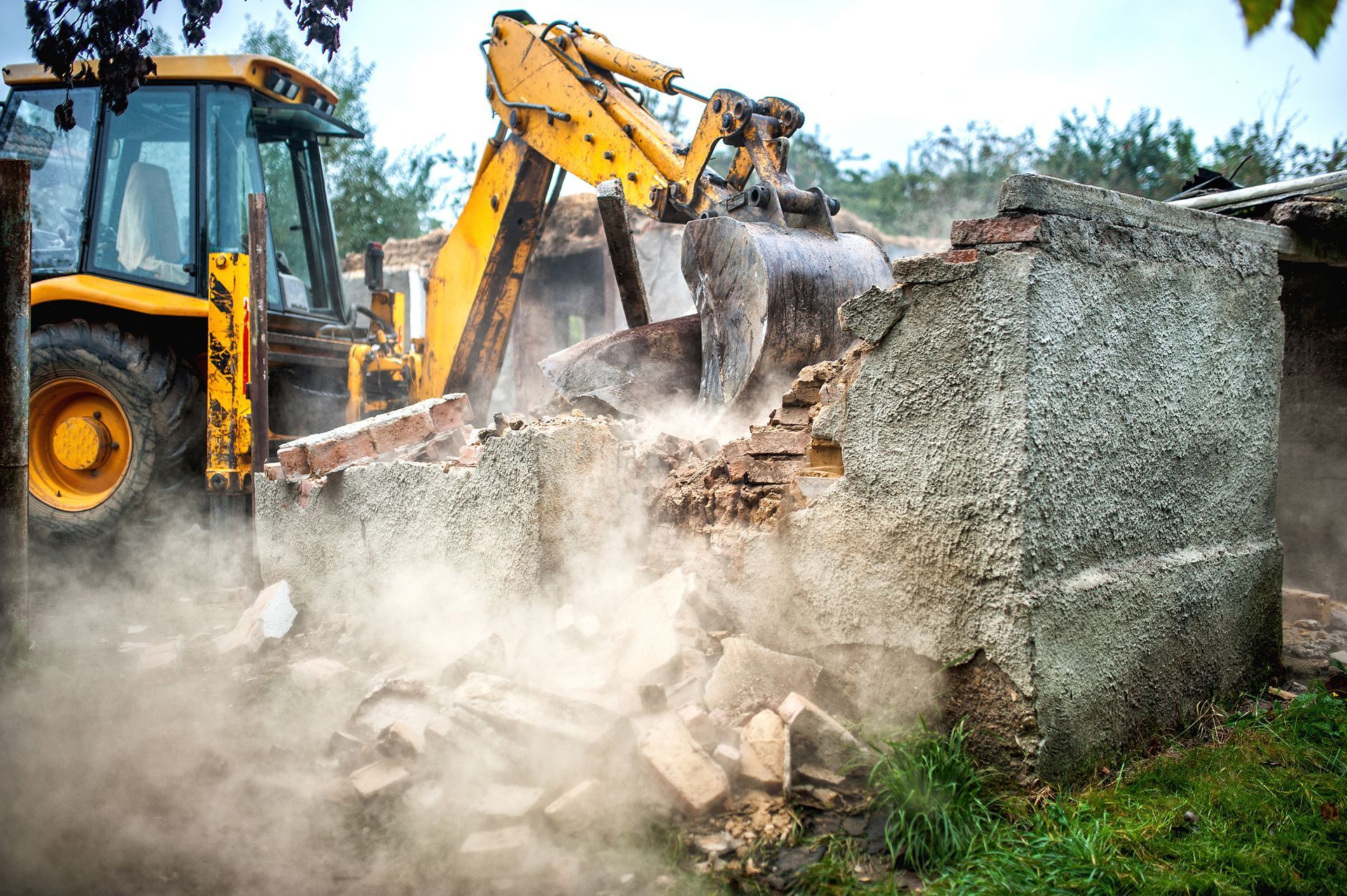 A yellow bulldozer is demolishing a building.