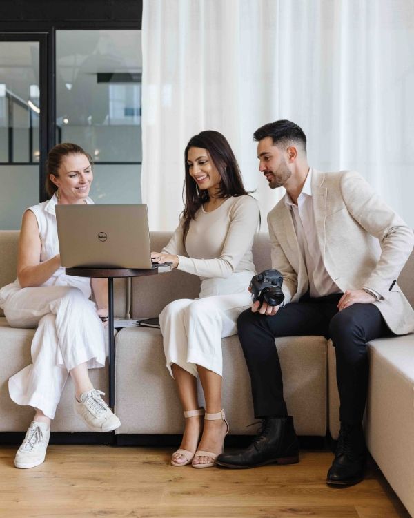 A smartphone displaying the Facebook login screen sits next to a notebook and pen on a white surface.