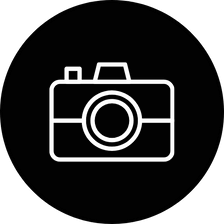 White camera icon on a black circle.