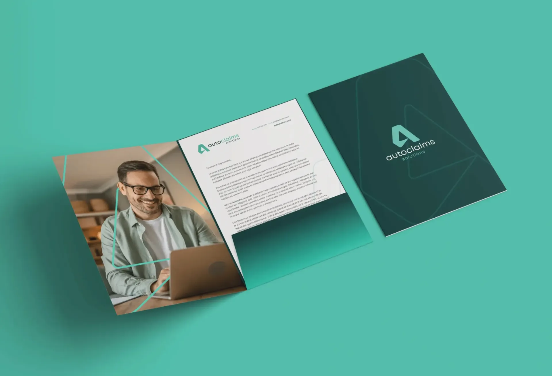 A man with glasses on a laptop sits near a letter inside a teal folder.