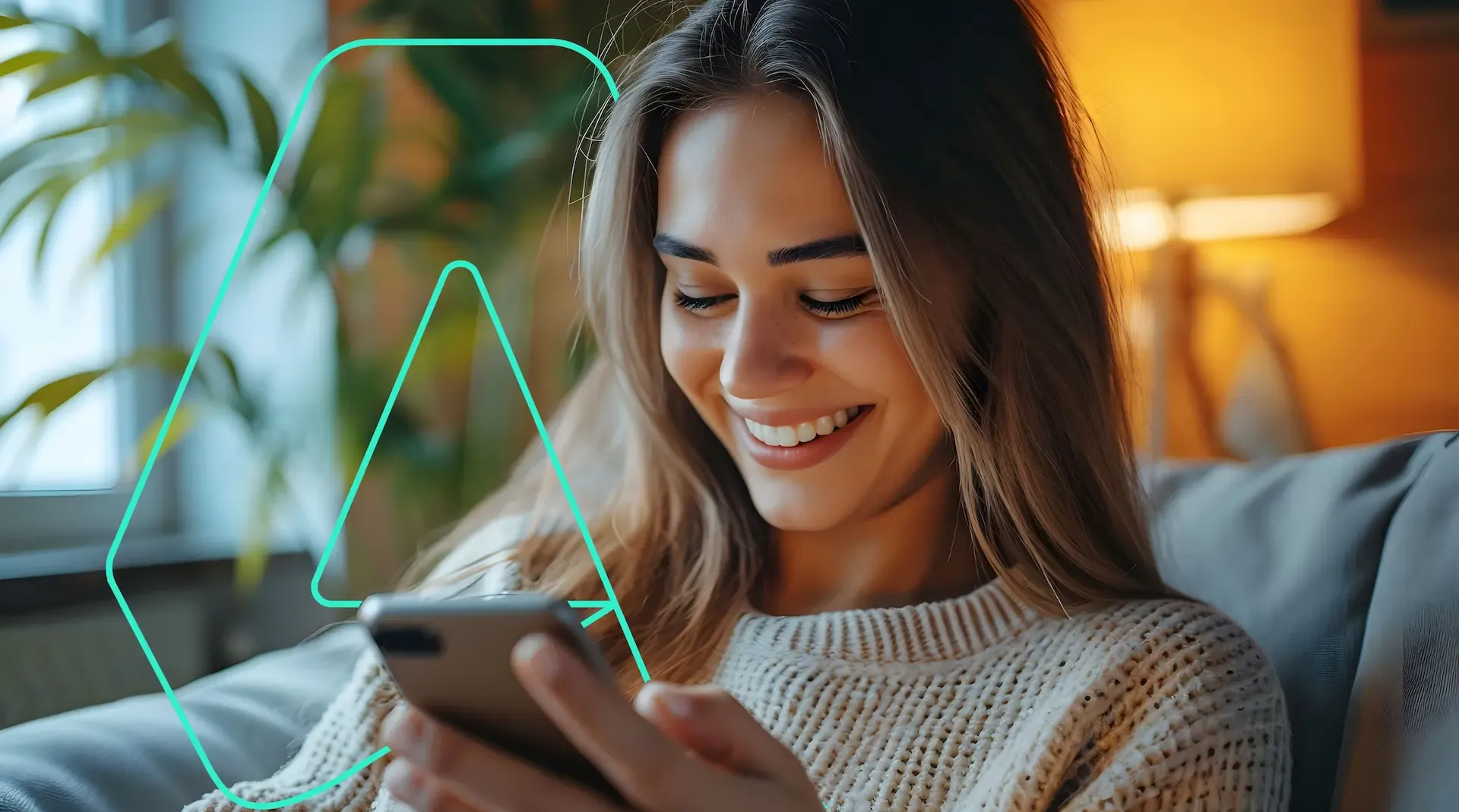 Woman smiles while using a smartphone. Green outline logo in corner. Warm indoor setting.