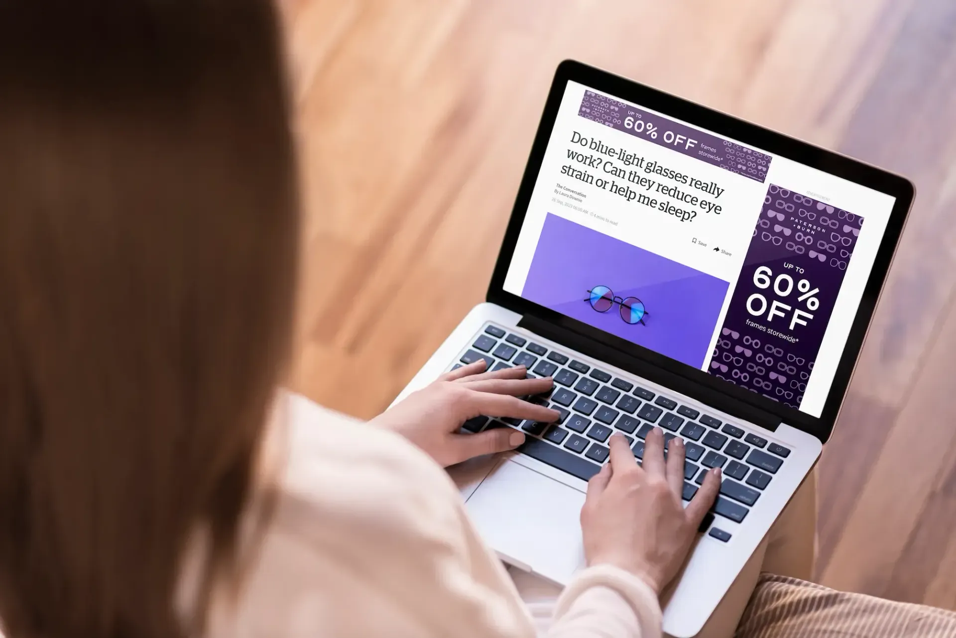Person using a laptop, looking at an advertisement with a 60% off discount.