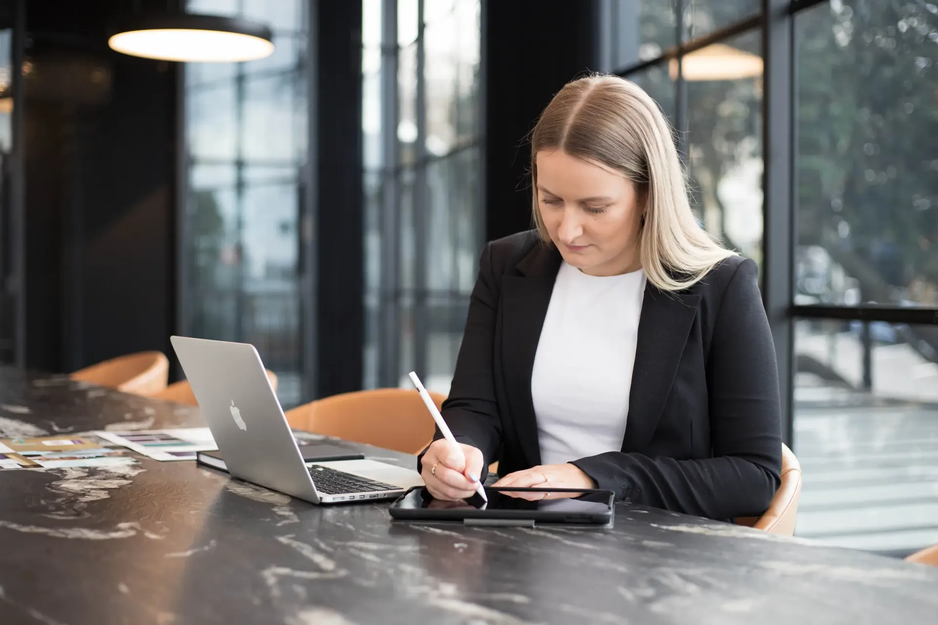 A smartphone displaying the Facebook login screen sits next to a notebook and pen on a white surface.