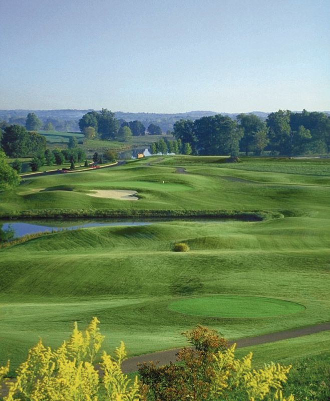 A golf course with a pond in the middle of it