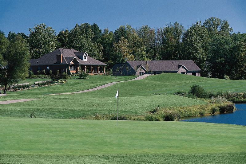 A golf course with a house in the background