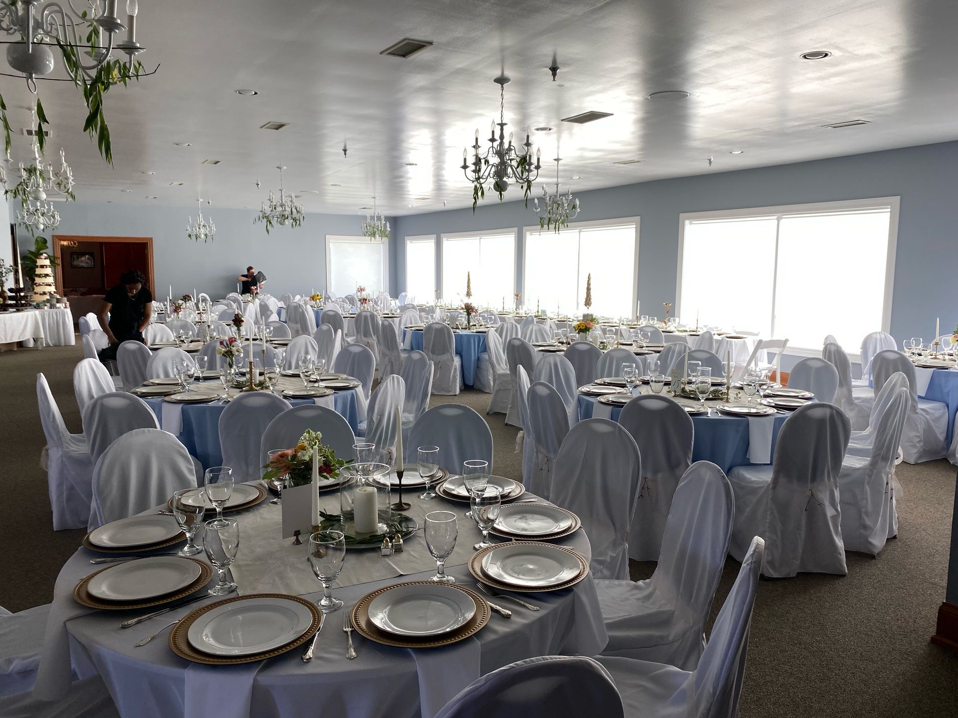 A large room with tables and chairs set up for a wedding reception