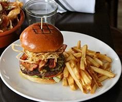 A house with a lot of windows is surrounded by trees