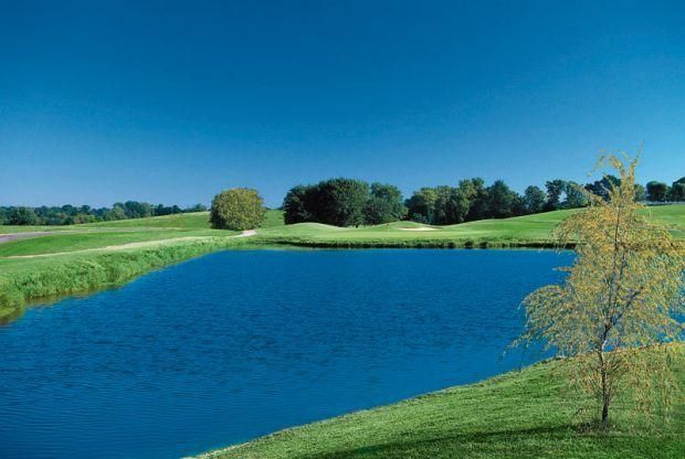 There is a lake in the middle of a golf course.