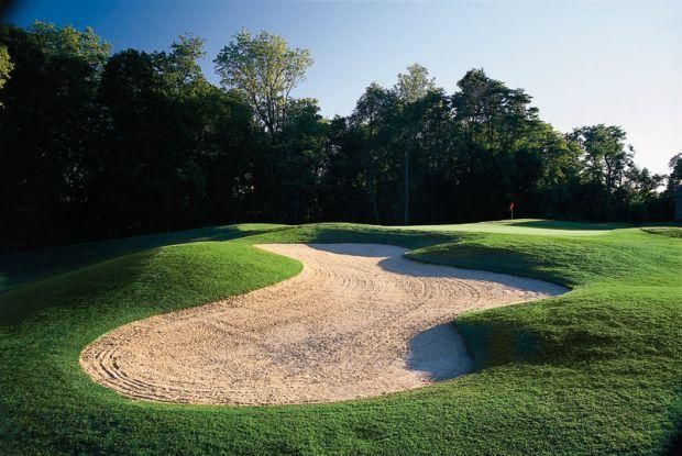 A golf course with a bunker in the middle of it