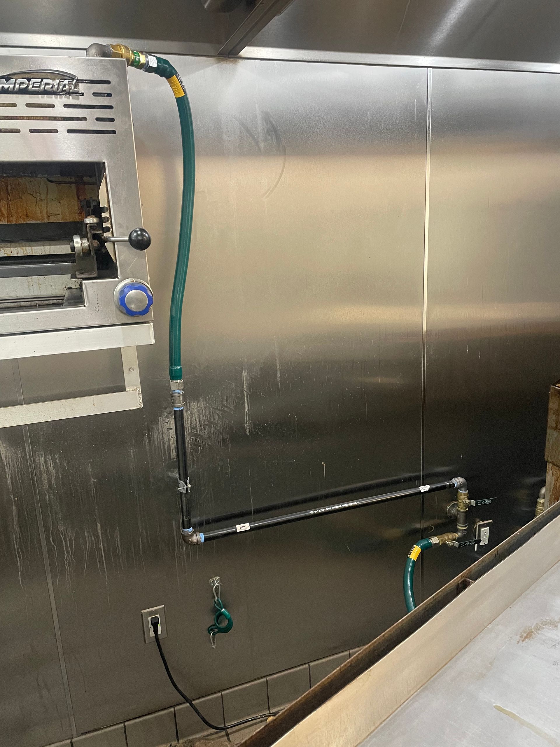 A stainless steel wall with a hose attached to it