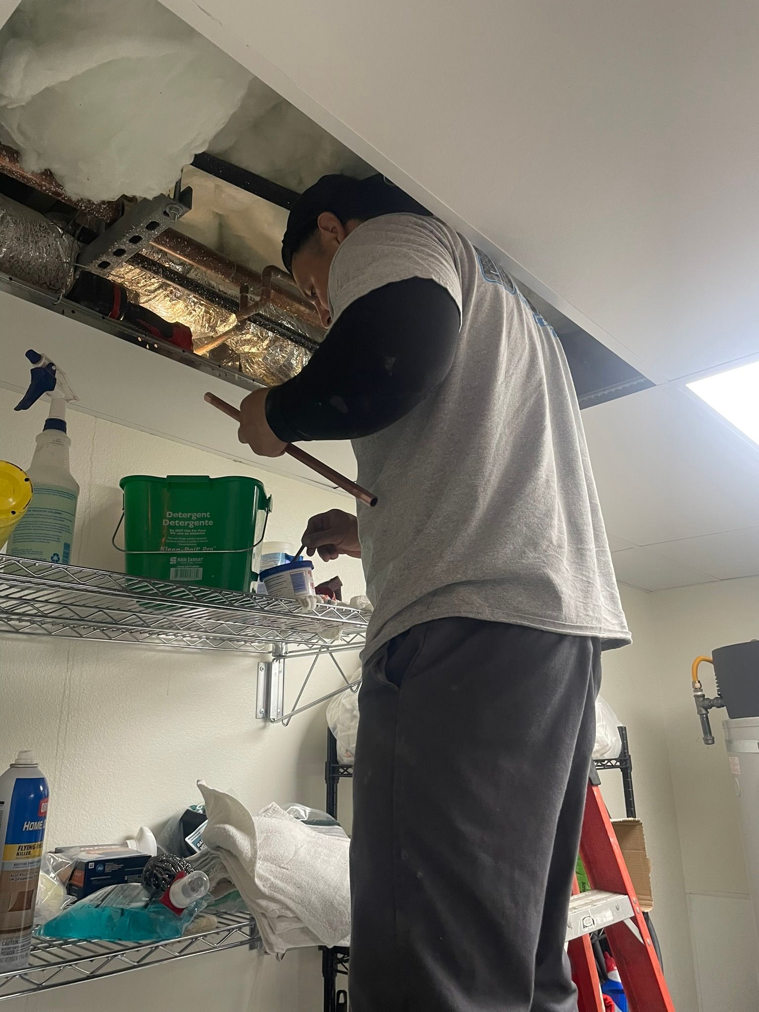 A man is working on a ceiling in a room.
