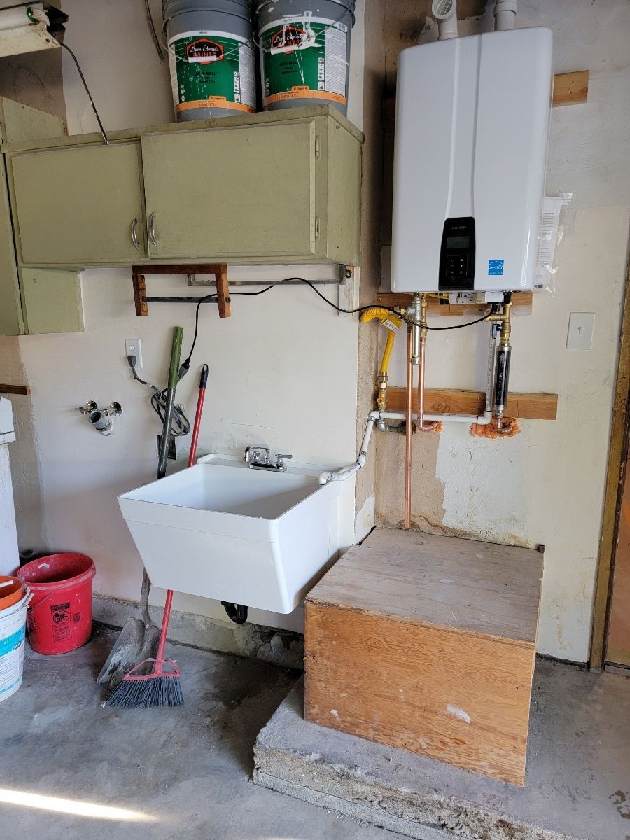 A laundry room with a sink and a heater.