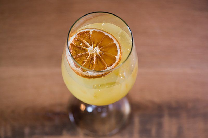 A close up of a glass of orange juice on a wooden table.