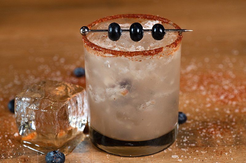 A close up of a drink in a glass on a table.