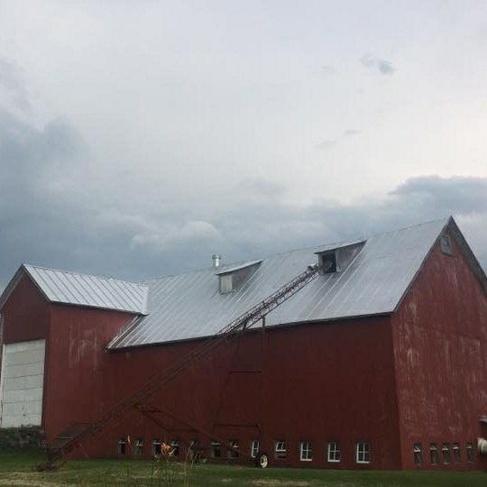 a red barn with a ladder on the roof