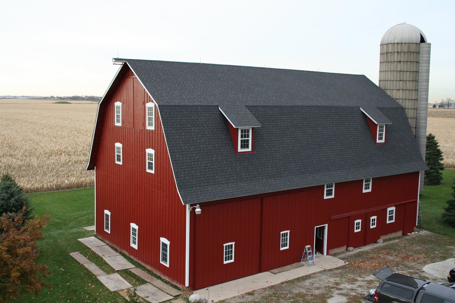a large red barn with a silo in the background