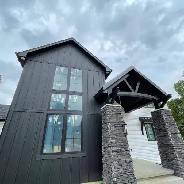 A black and white house with a stone porch