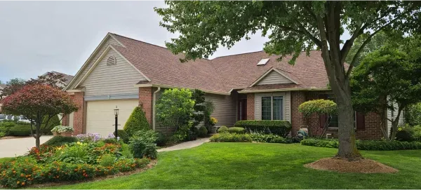 A large house with a red roof and a tree in front of it