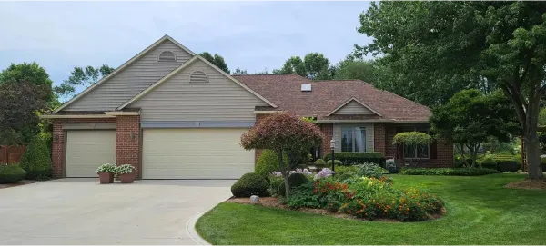 A brick house with a white garage door and a driveway