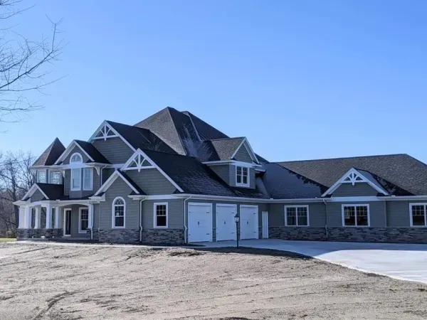 A large house with a lot of windows and a black roof