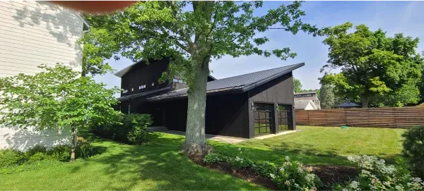 A house with a tree in front of it and a fence in the backyard.
