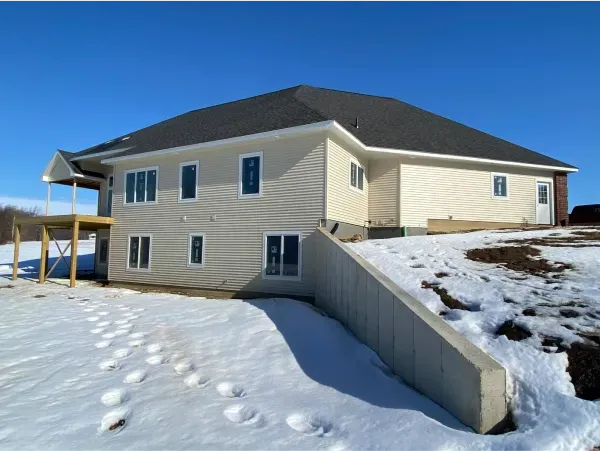 A large house sits on top of a snow covered hill