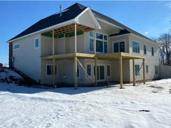 A large house with a large deck in the snow