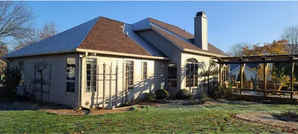 A large white house with a metal roof and a chimney