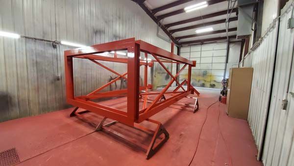 Red metal frame inside a spray paint booth.