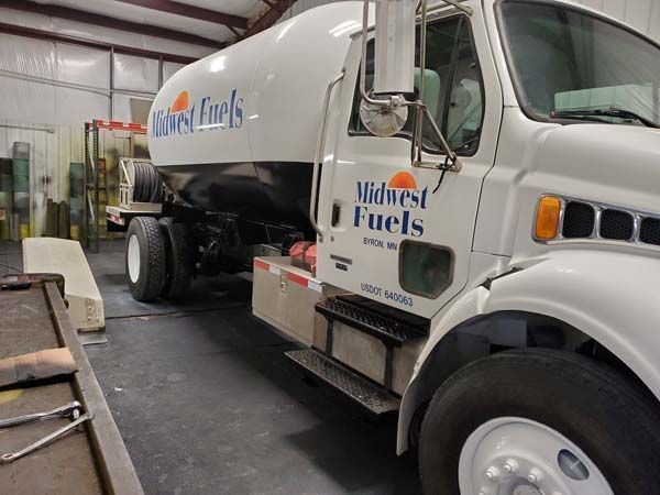 White Midwest Fuels tanker truck inside a warehouse.