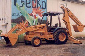 Bulldozer parked in front of Gecko Enterprises painted wall