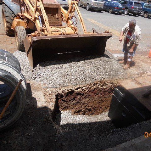 Bulldozer burying septic tank with gravel and dirt