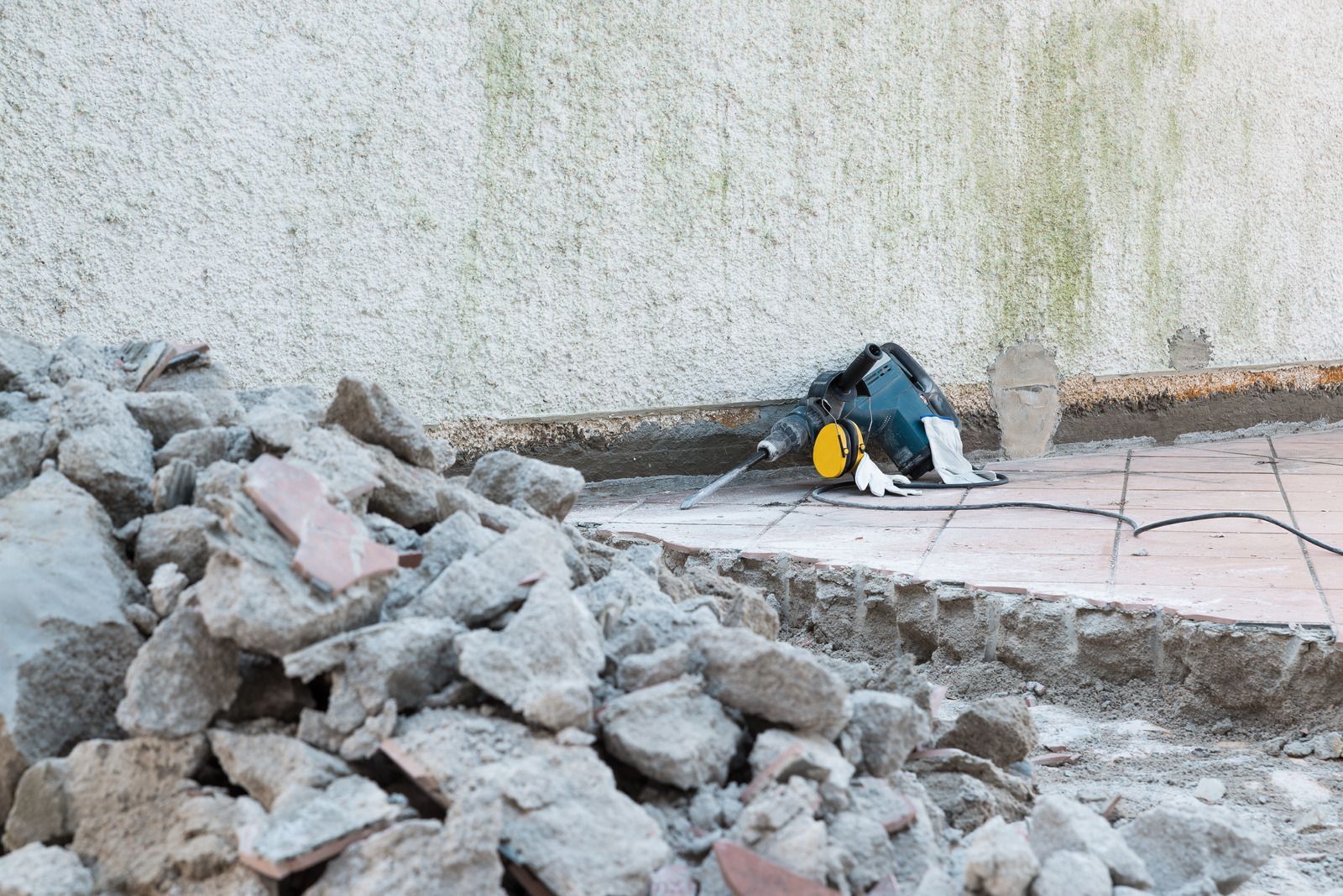 A pile of rocks and a hammer on a construction site.