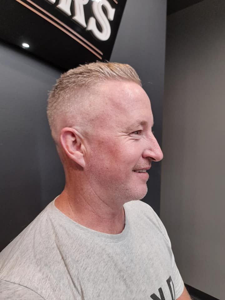 Man With Short Blonde Hair Smiling In Barbershop — Bolton Brothers Barbers in Erina, NSW