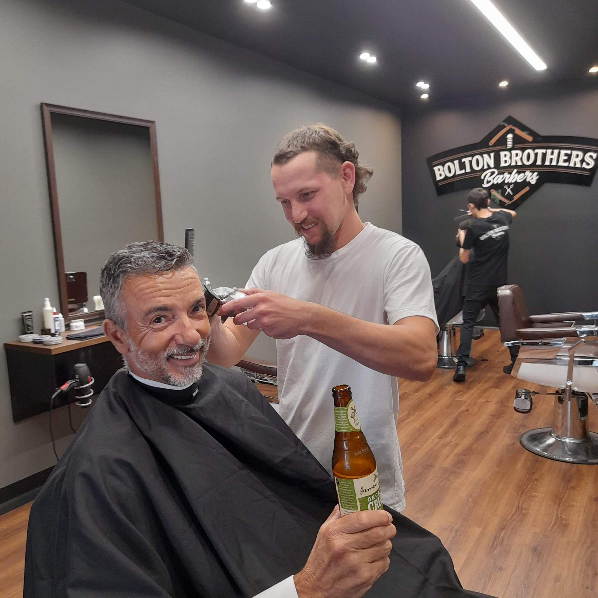 Man Getting Haircut Holding Beer — Bolton Brothers Barbers in Erina, NSW