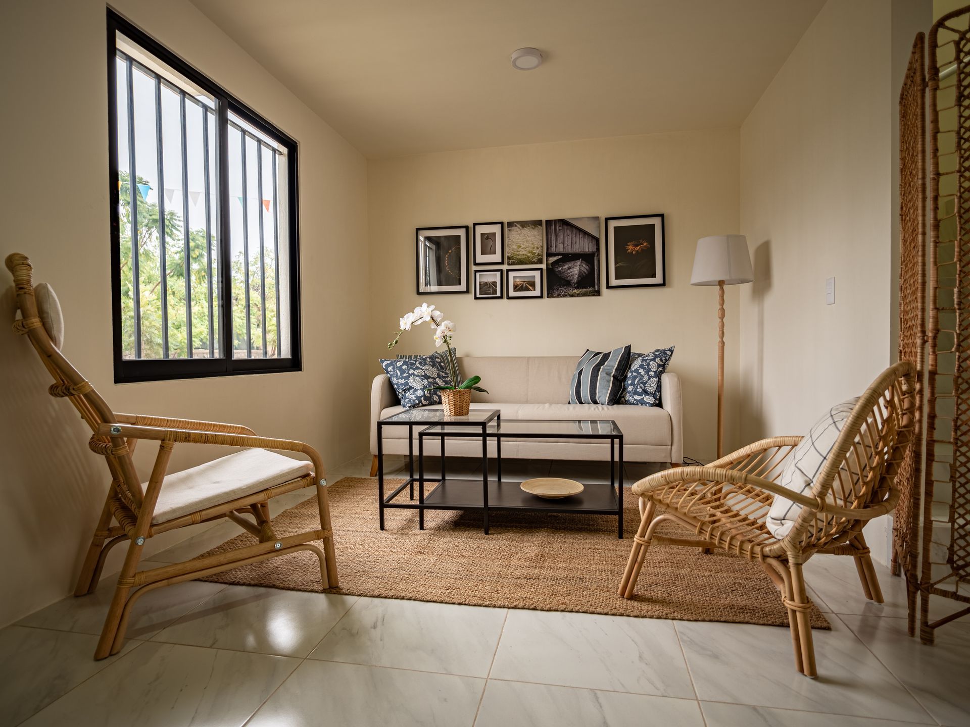 Una sala de estar con un sofá, dos sillas, una mesa de café y una ventana.